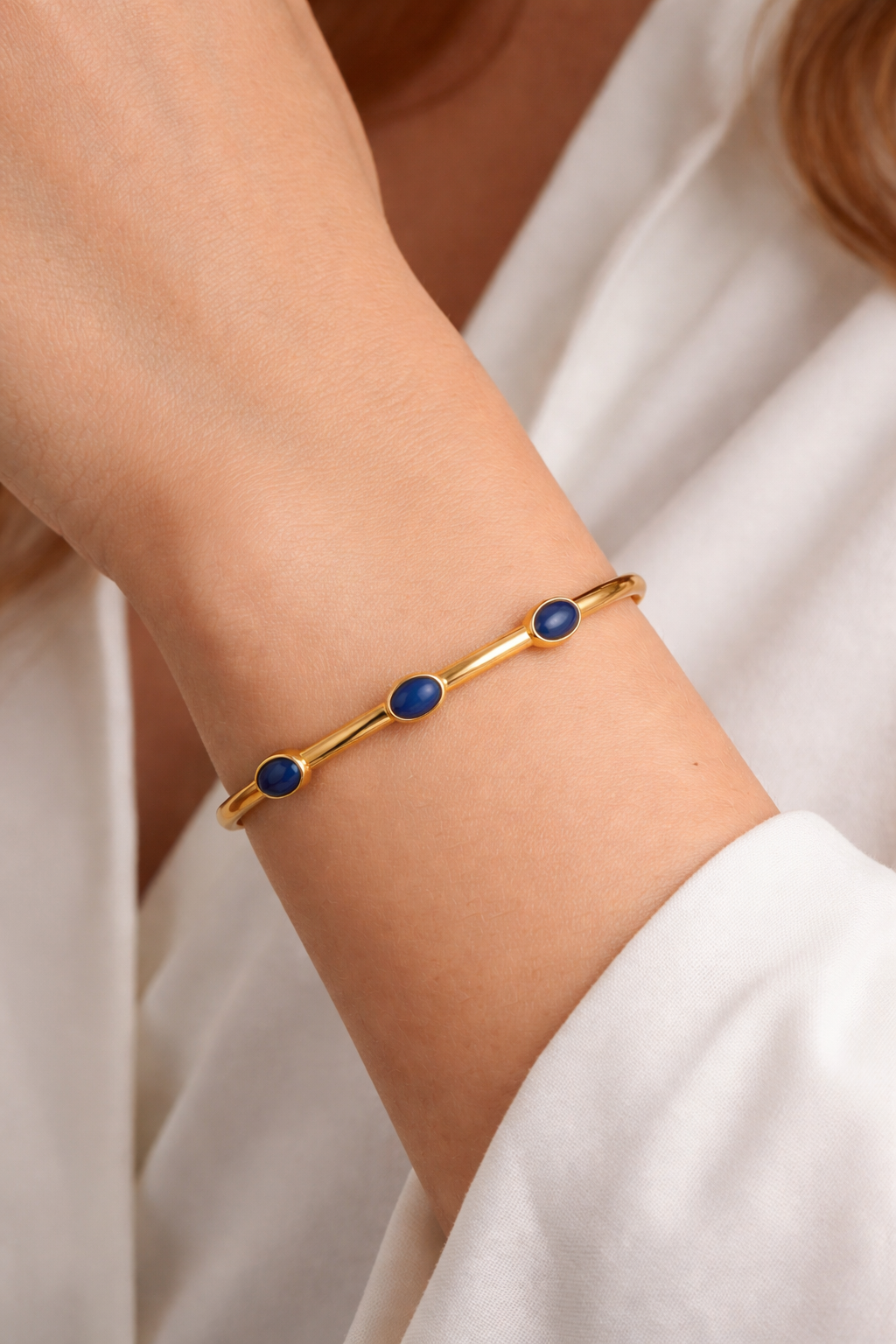 Trivena Cuff with three oval lapis lazuli stones in a minimal gold setting, showcasing calm strength and elegance