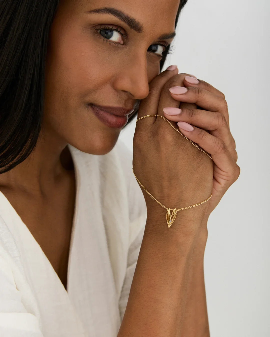 V वी Initial Necklace, delicate gold-tone chain with a small angular V-shaped pendant, worn on the wrist
