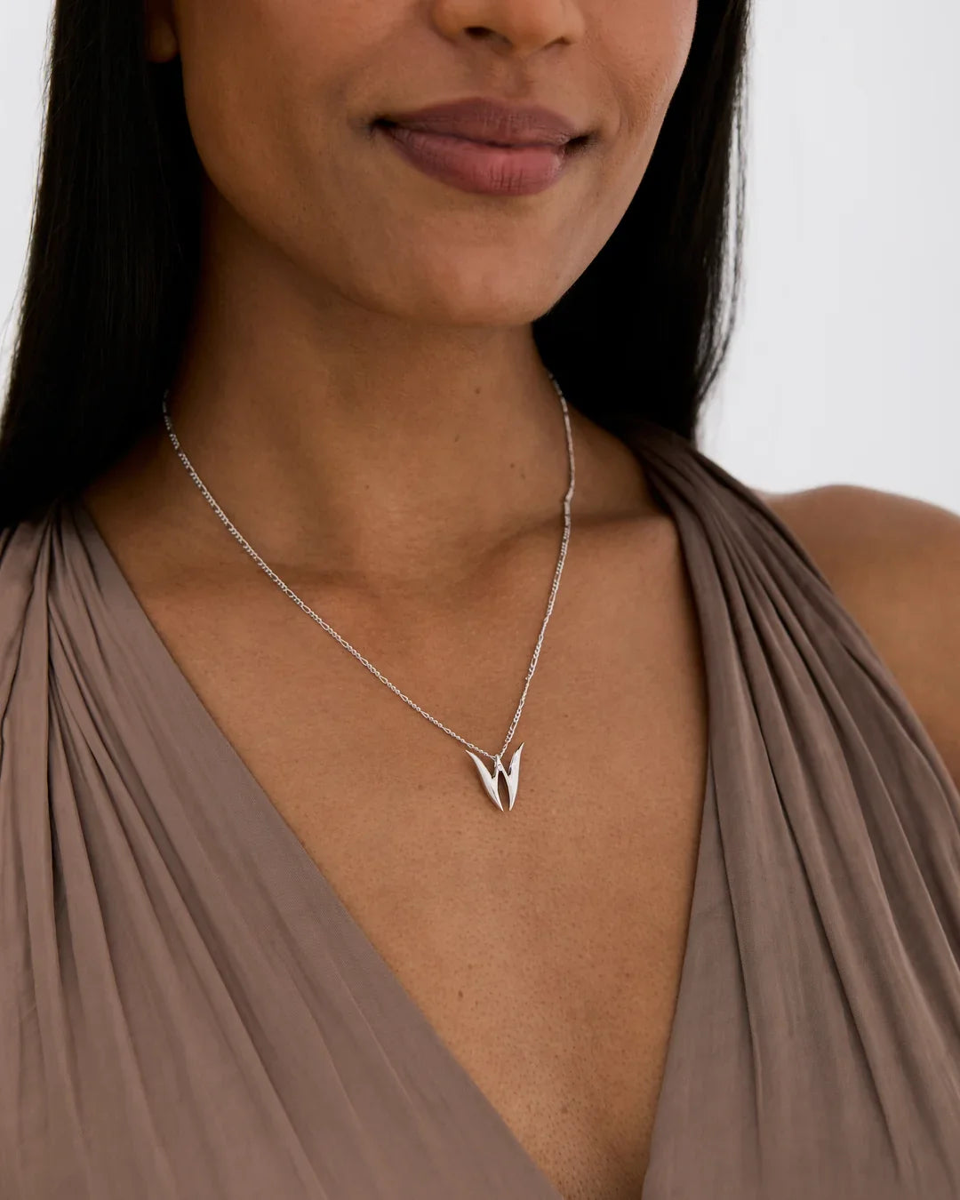 W डब्ल्यू Initial Necklace in polished silver-toned metal, with a fine chain and a pointed double-return W-shaped pendant.